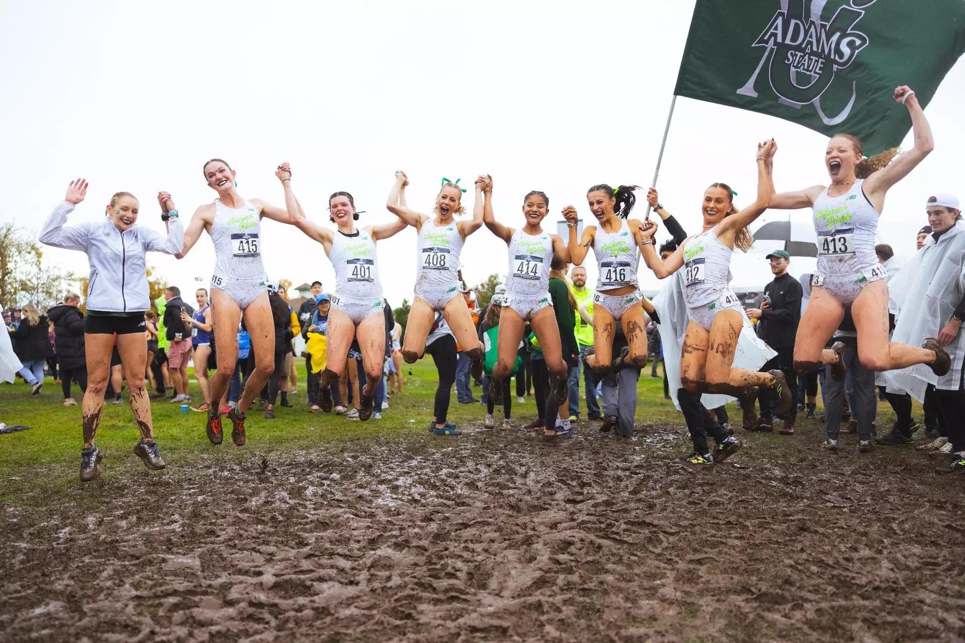 The Adams State women's cross country team jumps for joy.