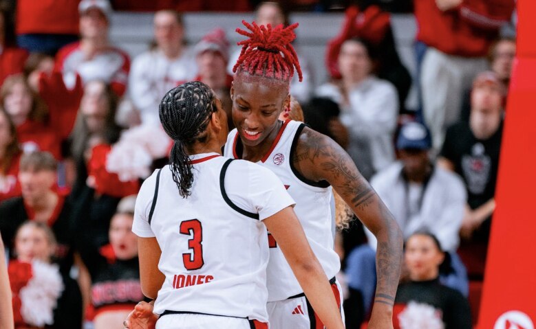 Players from NC State women's basketball hug in celebration